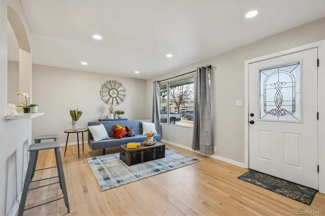 a living room with furniture and a wooden floor