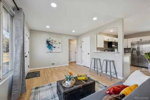 a living room with furniture kitchen view and a flat screen tv