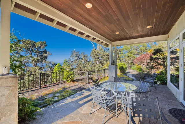 a patio with table and chairs and potted plants