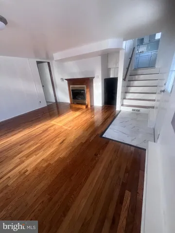 a view of empty room with wooden floor and fireplace