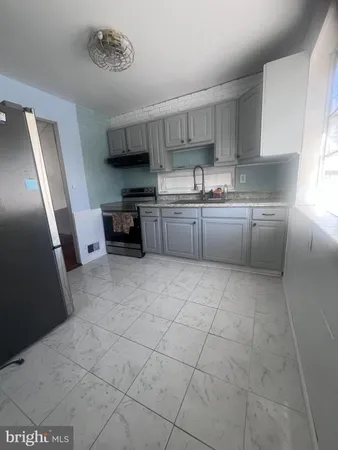 a kitchen with a sink a stove top oven and cabinets