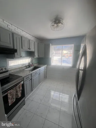 a kitchen with stainless steel appliances granite countertop a stove a sink a refrigerator and cabinets