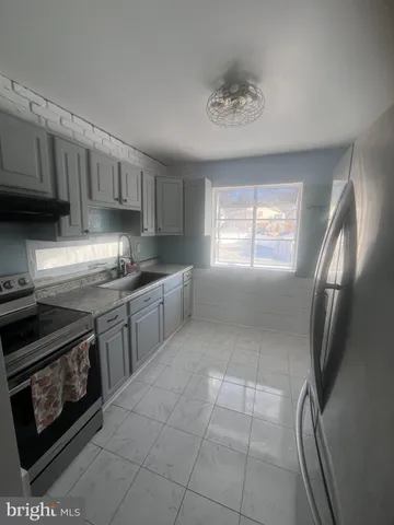 a kitchen with stainless steel appliances granite countertop a stove a sink a refrigerator and cabinets