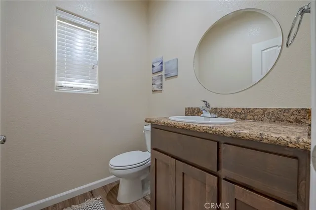 a bathroom with a granite countertop toilet sink and mirror