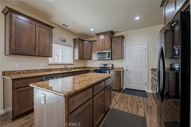 a kitchen with a refrigerator sink and cabinets
