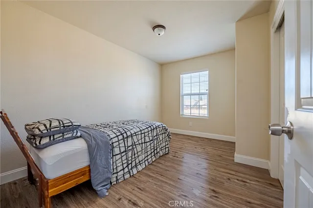a bedroom with a bed and wooden floor