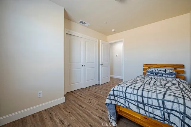 a bedroom with a bed and wooden floor