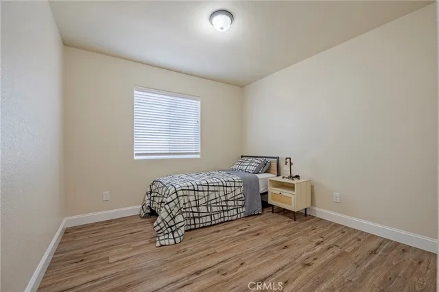 a bedroom with a bed and wooden floor