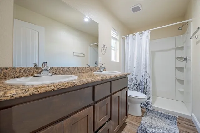 a bathroom with a granite countertop sink toilet and shower