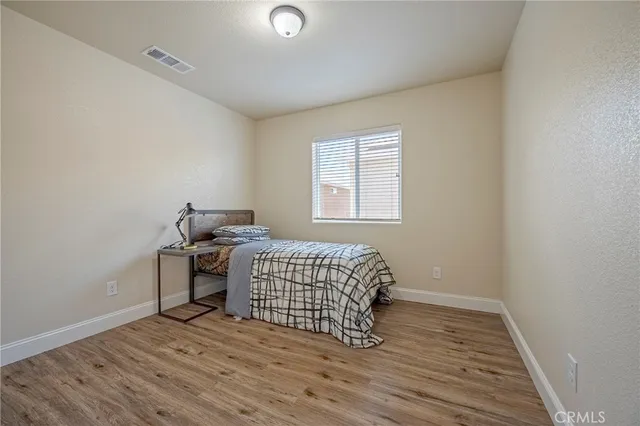 a room with a bed and wooden floor