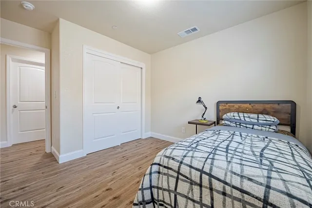 a bedroom with a bed and wooden floor