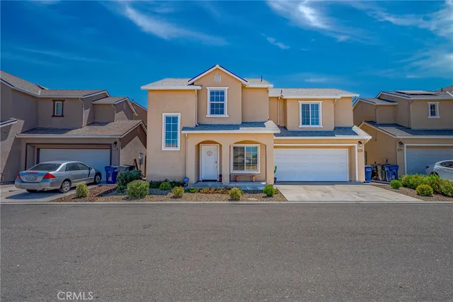 a front view of a building with lot of cars and trees