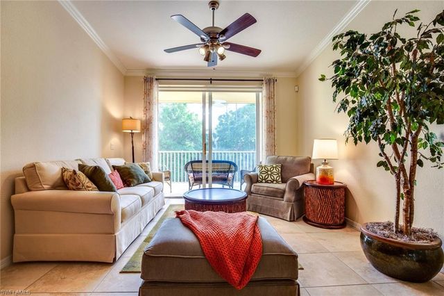 a living room with furniture a large window and a chandelier