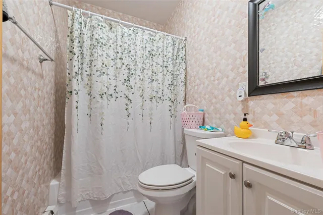 a bathroom with a sink a toilet and shower curtain