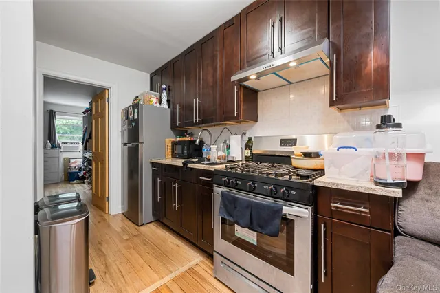 a kitchen with stainless steel appliances granite countertop a stove a refrigerator and a sink