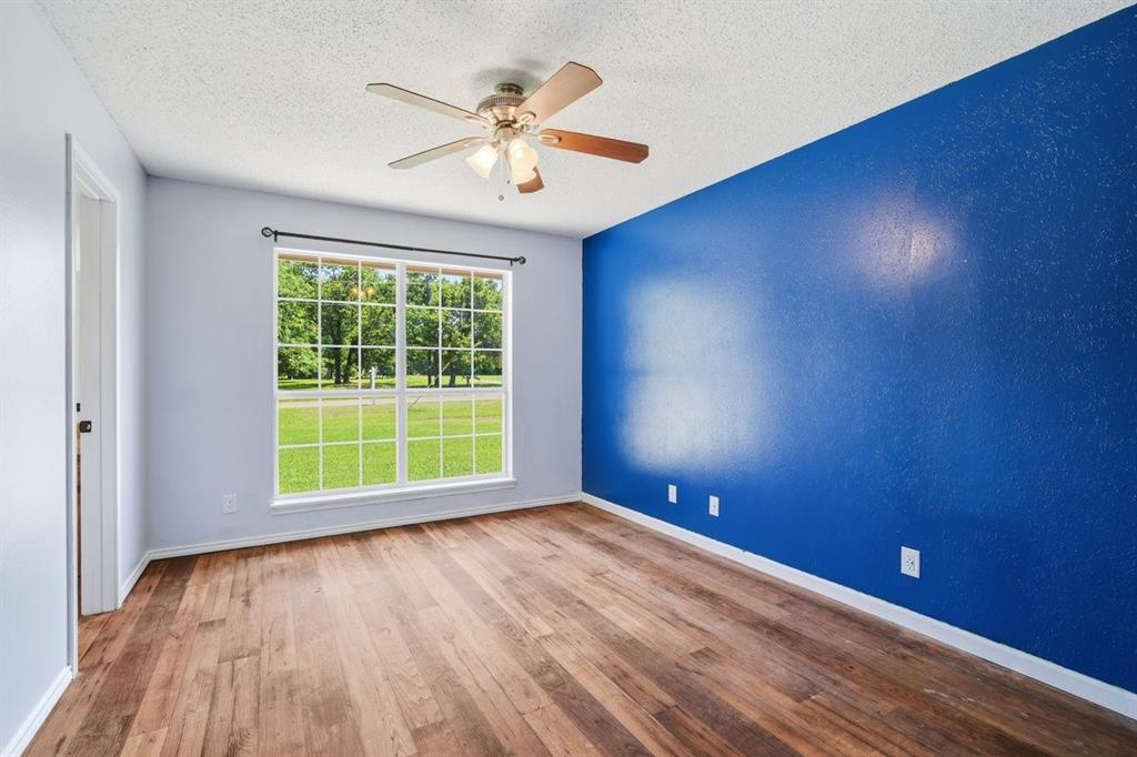 1974 County Road Powderly, TX 75473 - Photo 17 of 28 an empty room with wooden floor and windows