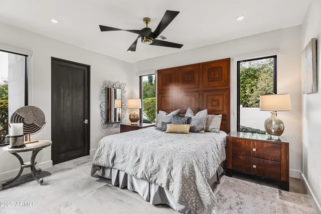 a bedroom with a bed and large windows