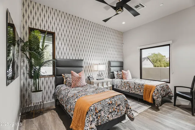 a bedroom with two beds and a potted plant