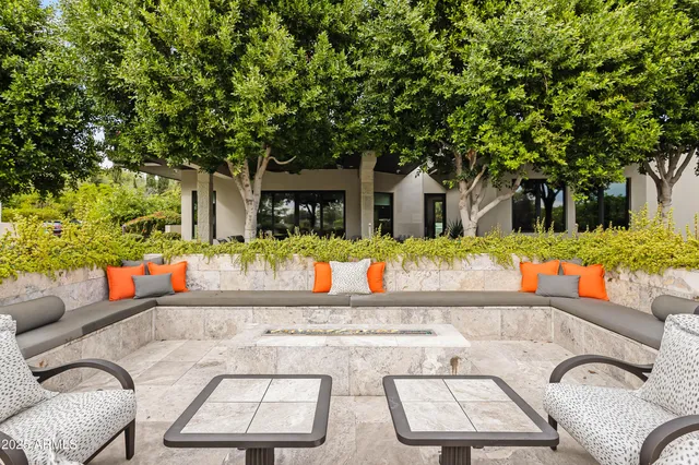 a view of a chairs and fire pit in the back yard