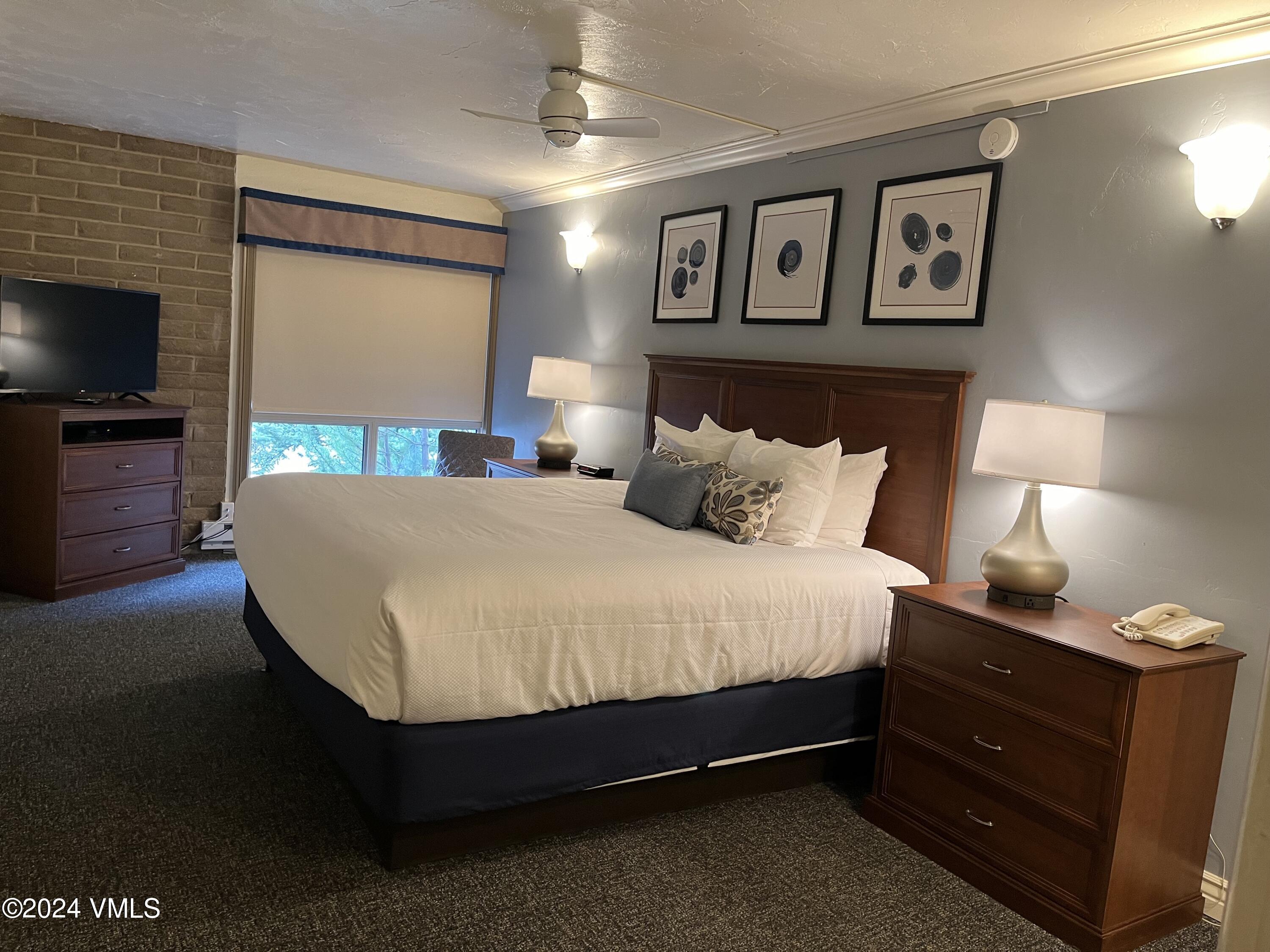 1020 Vail View Drive, Unit 131138 Vail, CO 81657 - Photo 8 of 19 a spacious bedroom with a bed and a flat screen tv