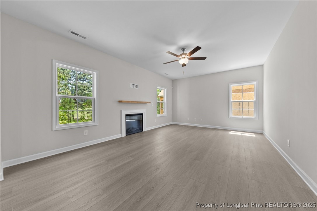 509 Watauga Lane Aberdeen, NC 28315 - Photo 13 of 29 an empty room with windows fireplace and wooden floor