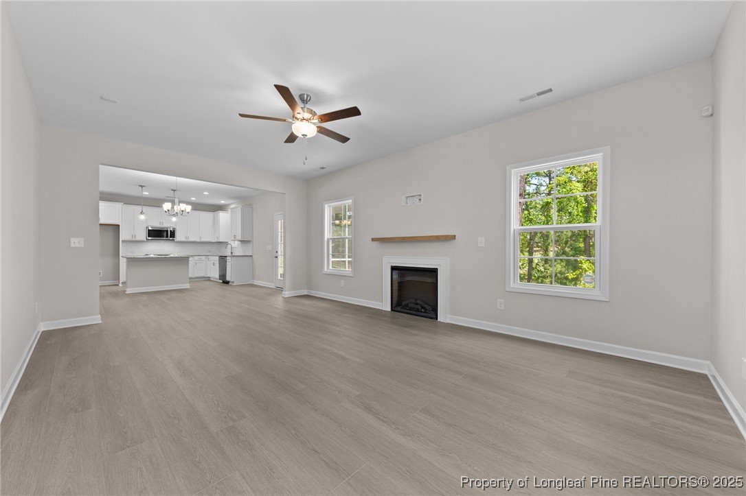 509 Watauga Lane Aberdeen, NC 28315 - Photo 14 of 29 an empty room with windows fireplace and a kitchen view