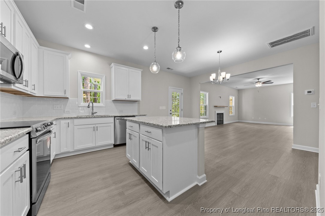 509 Watauga Lane Aberdeen, NC 28315 - Photo 8 of 29 a kitchen with kitchen island granite countertop a sink cabinets and stainless steel appliances