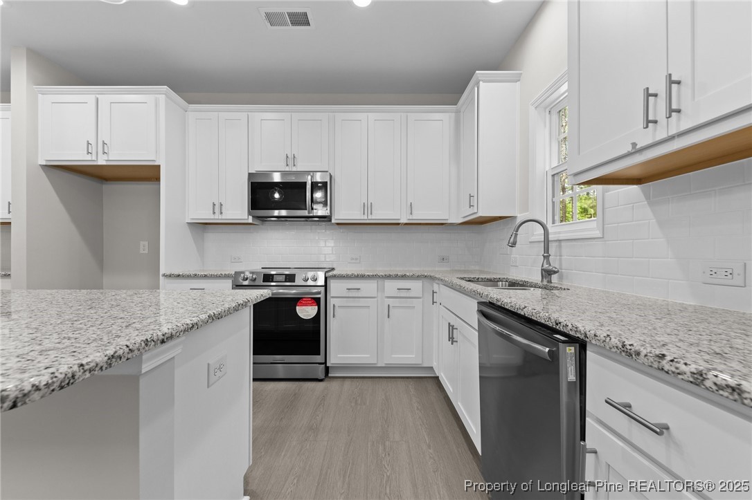 509 Watauga Lane Aberdeen, NC 28315 - Photo 10 of 29 a kitchen with stainless steel appliances granite countertop a sink stove and cabinets