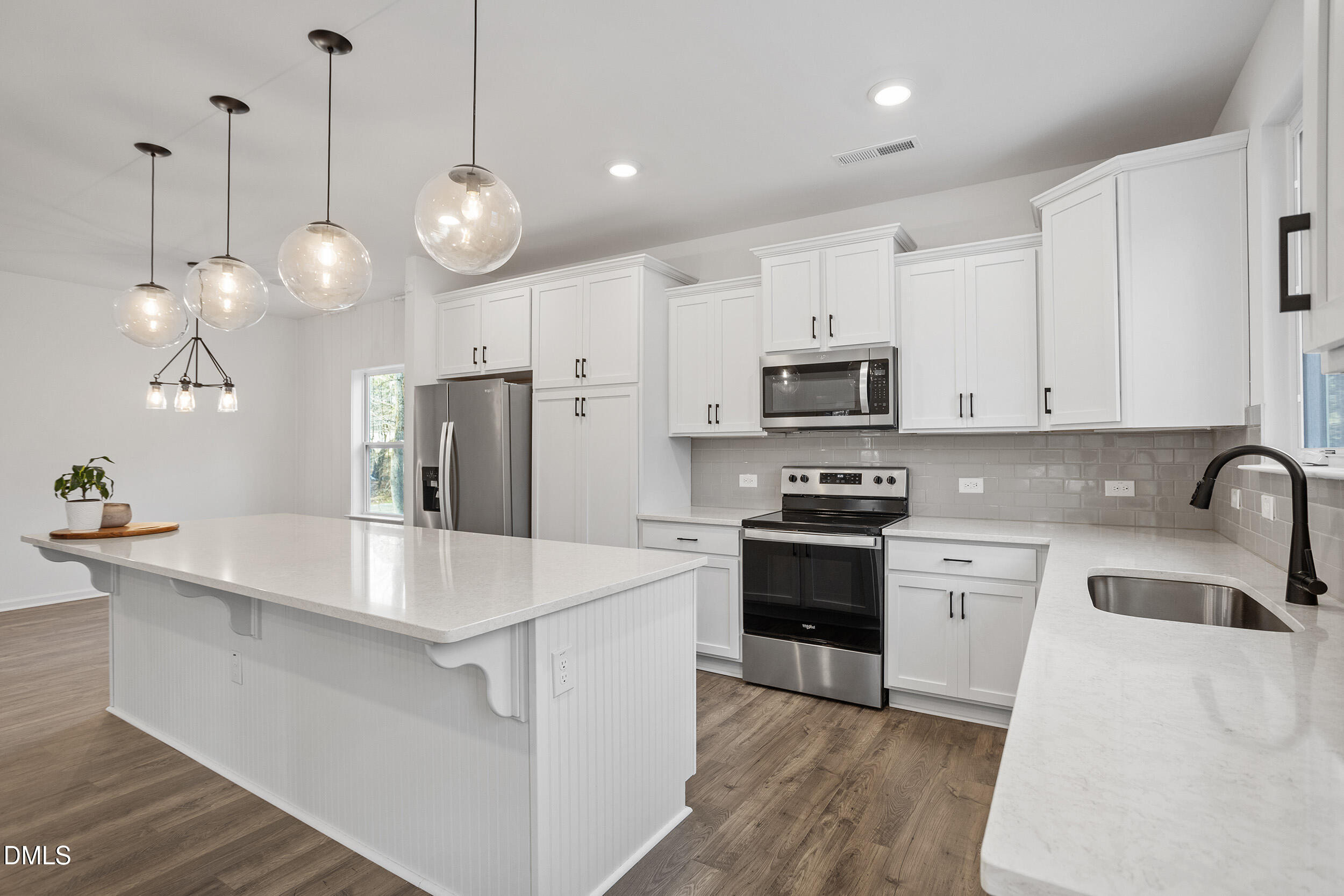 138 Sacred Fire Road Louisburg, NC 27549 - Photo 12 of 28 a large white kitchen with stainless steel appliances granite countertop a stove a sink a refrigerator a microwave oven a white table and chairs with wooden floor
