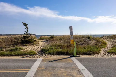 a street sign on a sidewalk next to a road