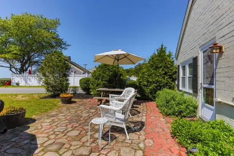 a view of a patio with table and chairs under an umbrella