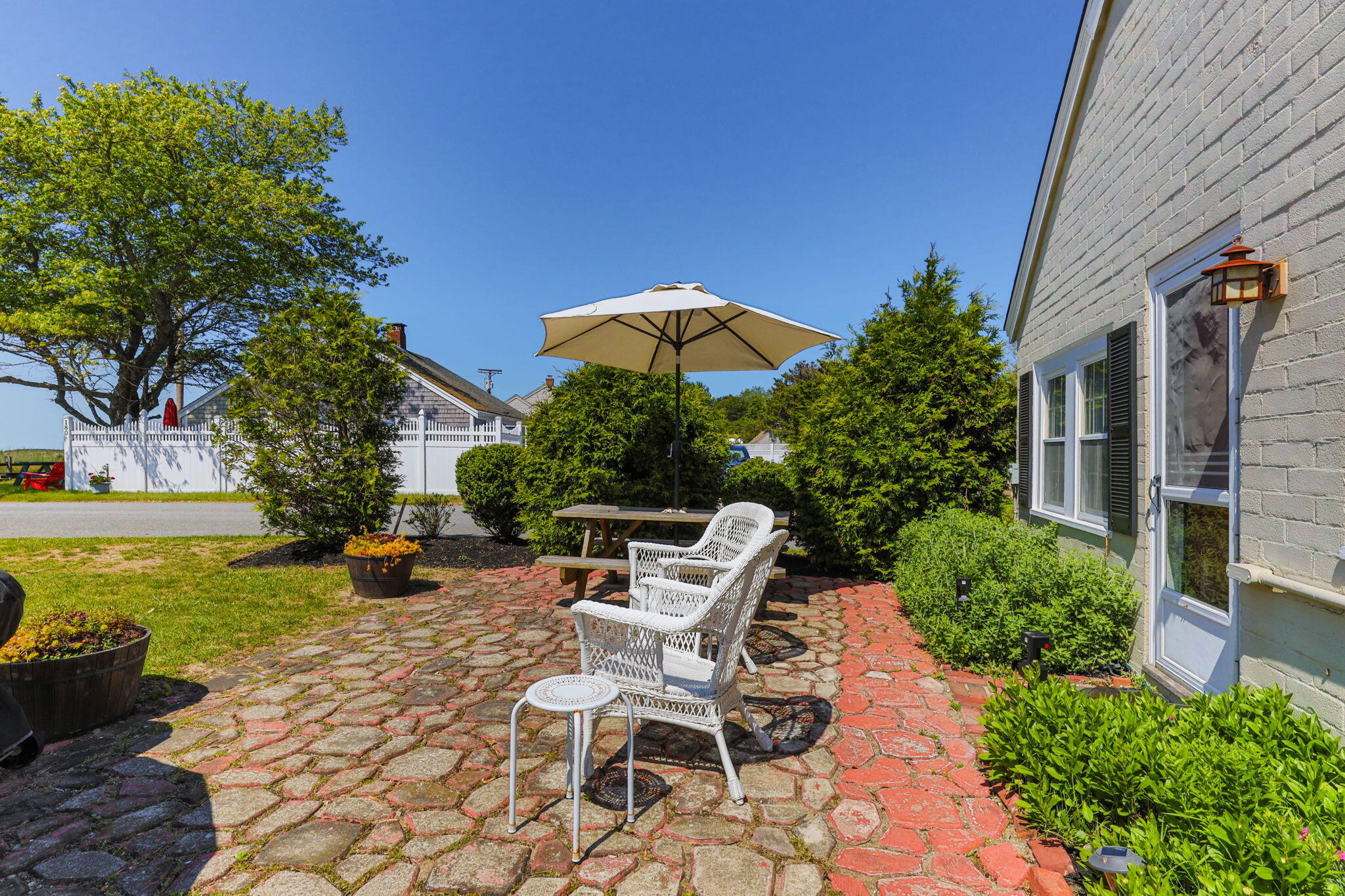 164 Kendrick Avenue, Unit C Wellfleet, MA 02667 - Photo 5 of 27 a view of a patio with table and chairs under an umbrella