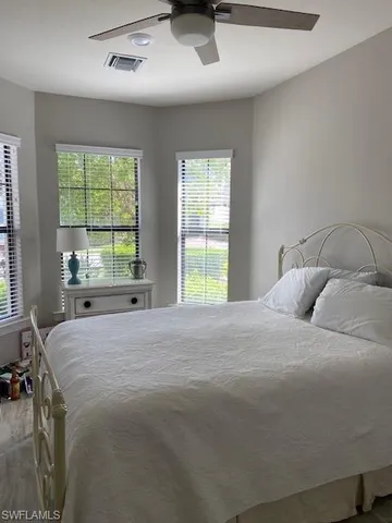 a bedroom with a bed and a large window