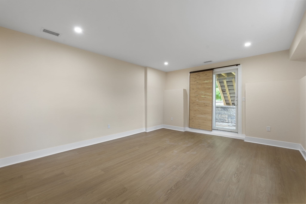 123 Nottinghill Road, Unit 2 Boston, MA 02135 - Photo 20 of 30 an empty room with wooden floor and windows