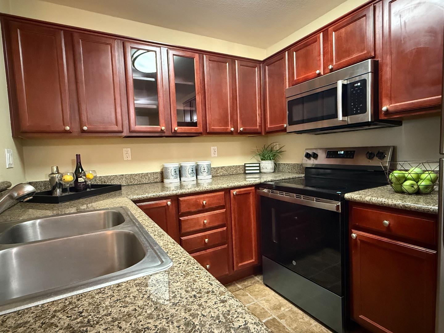 a kitchen with stainless steel appliances granite countertop a sink stove and microwave