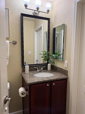 a bathroom with a granite countertop sink and a mirror