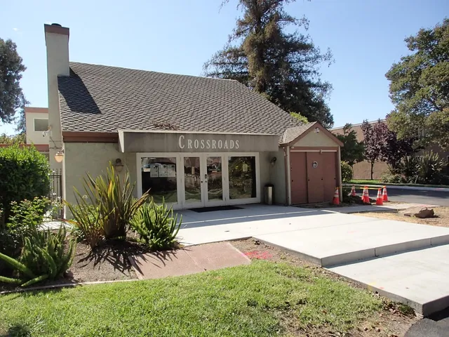 a front view of a house with a yard and potted plants