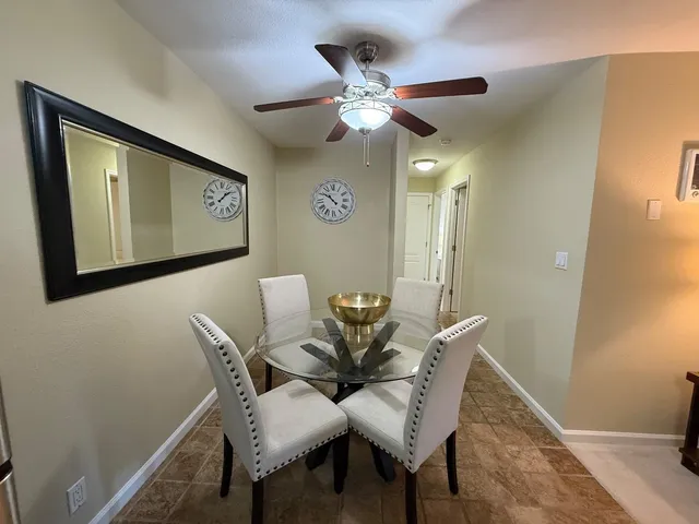 a view of a dining room with furniture and a chandelier fan