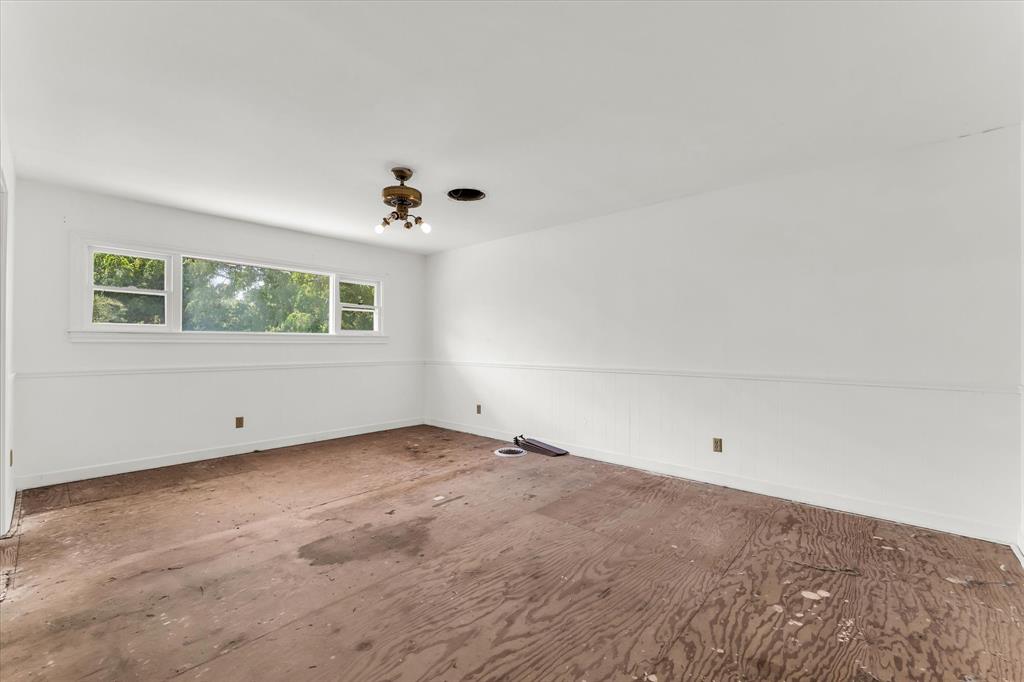 421 Rice Avenue Waco, TX 76708 - Photo 27 of 40 Upstair stairs, at the end of the hallway Bedroom suite, with its own bathroom, white walls with a chair rail and paneling, multiple windows, and a ceiling-mounted light fixture
