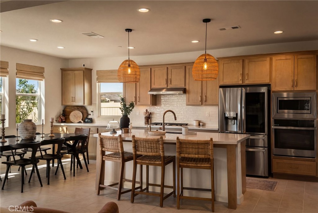 32259 Hillstone Street Temecula, CA 92591 - Photo 2 of 62 a kitchen with stainless steel appliances kitchen island granite countertop a table chairs and a refrigerator