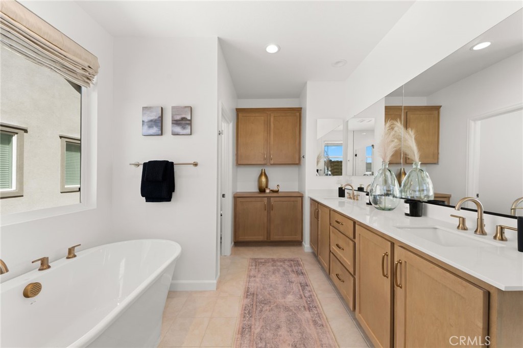 32259 Hillstone Street Temecula, CA 92591 - Photo 25 of 62 a large bathroom with a double vanity sink a mirror and a bathtub