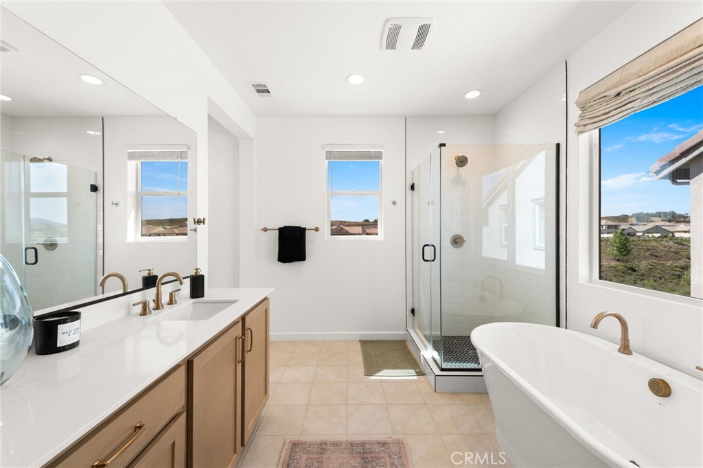32259 Hillstone Street Temecula, CA 92591 - Photo 26 of 62 a bathroom with a tub a sink and a large mirror