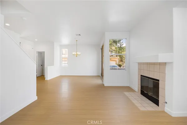 an empty room with windows and fireplace