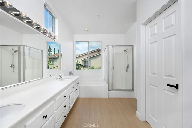 a spacious bathroom with a double vanity sink a mirror and a shower