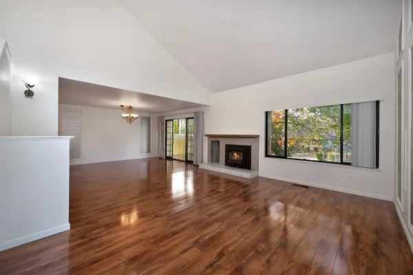 a view of empty room with wooden floor and fireplace