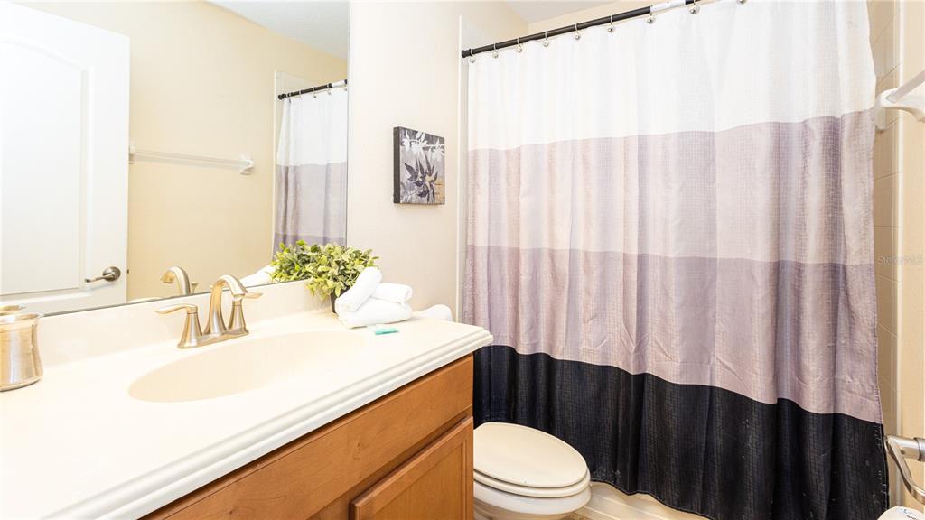 2977 Buccaneer Palm Road Kissimmee, FL 34747 - Photo 28 of 66 a bathroom with a sink a toilet and shower curtain