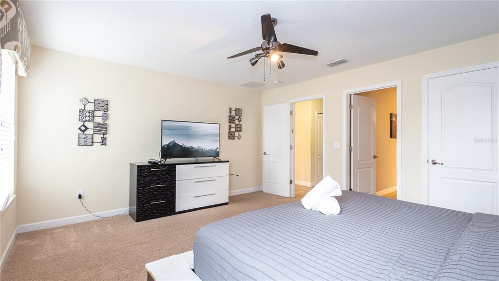 2977 Buccaneer Palm Road Kissimmee, FL 34747 - Photo 33 of 66 a bedroom with a bed and a chandelier