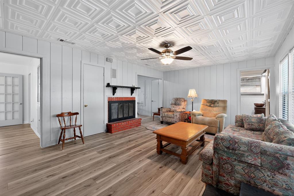 5485 Highway 7 Marlin, TX 76661 - Photo 16 of 36 Living area featuring an ornate ceiling, light wood-style flooring, a brick fireplace, and ceiling fan