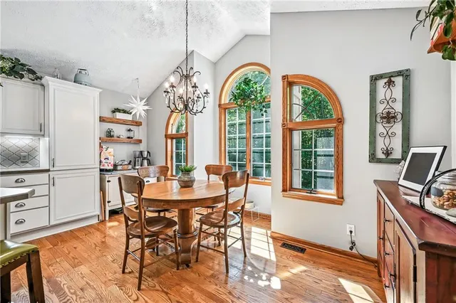 a dining room with furniture a chandelier and wooden floor