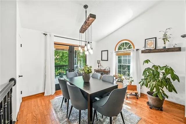 a dining room with furniture potted plants and wooden floor